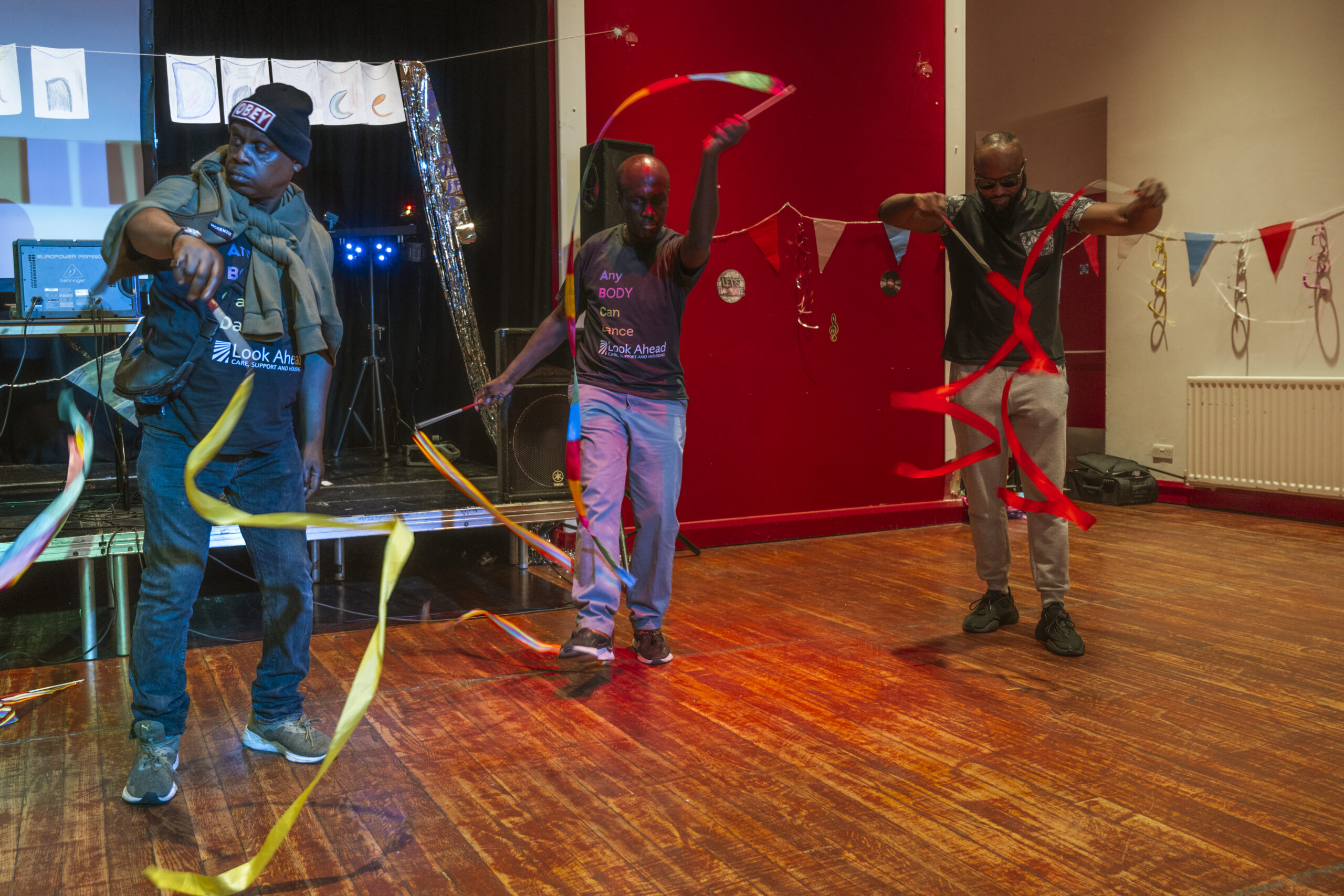 Two customers from Look Ahead's Hackney mental health service and their support worker enjoying inclusive dance activities and using ribbons as part of their performance.